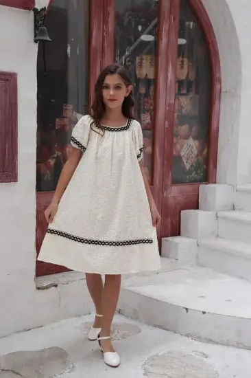 صورة فستان بناتي ابيض ونقوش سوداء